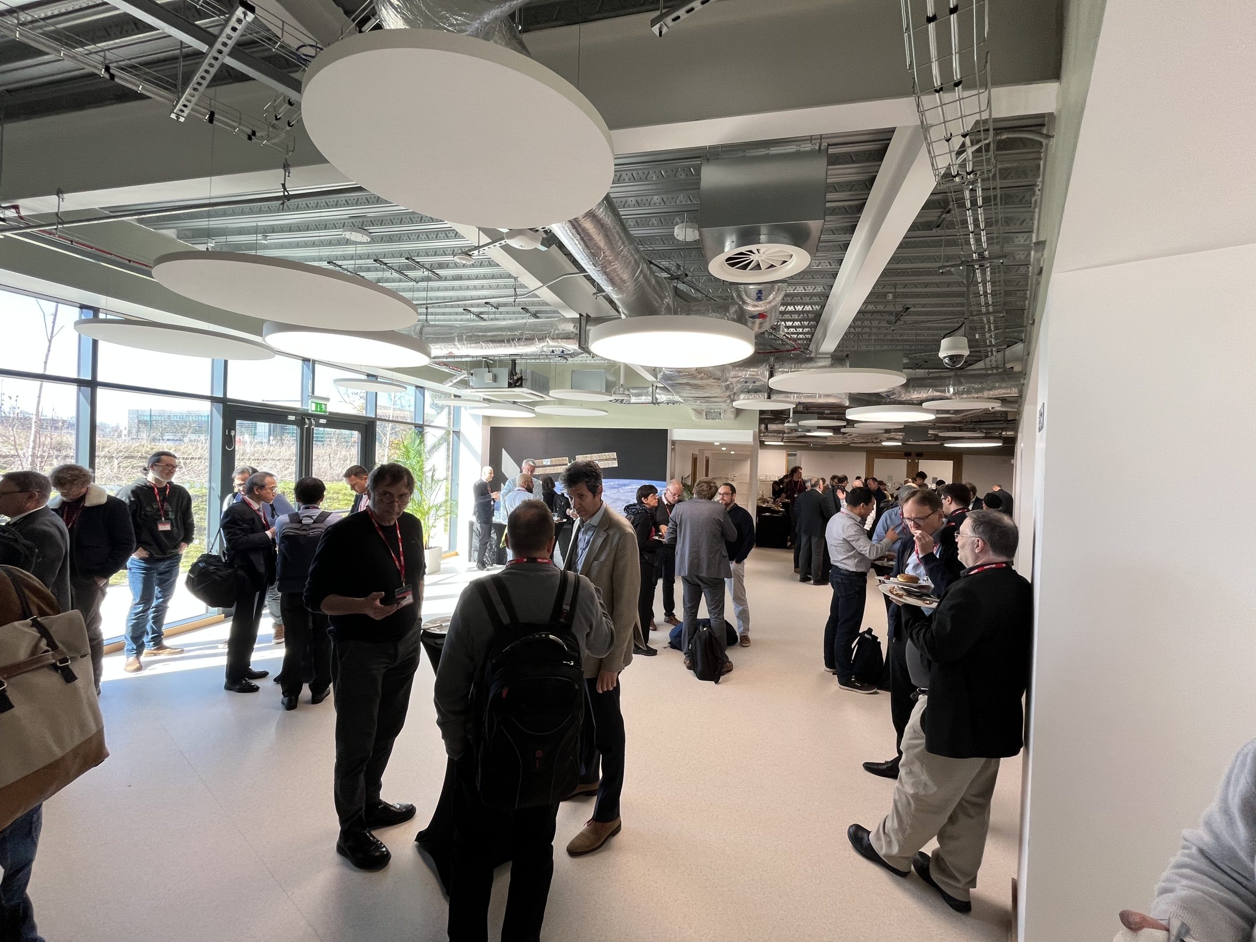 A room of people talking in a large room. The room is well lit